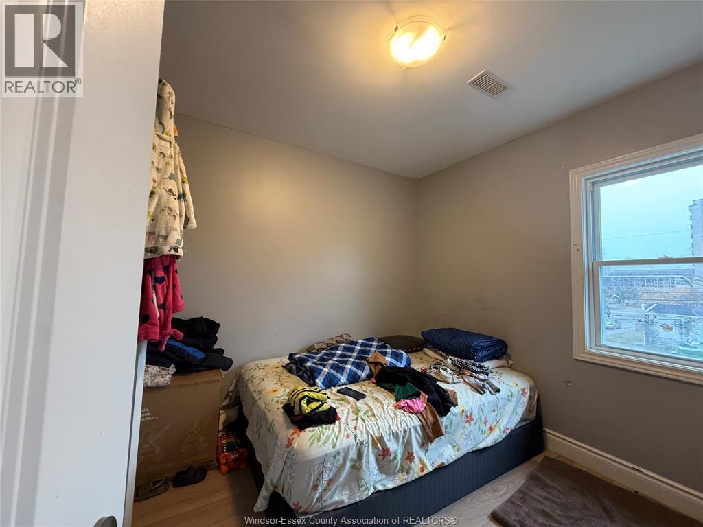 A bedroom with a bed, pillows, and a window.