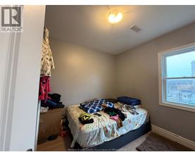 A bedroom with a bed, pillows, and a window.
