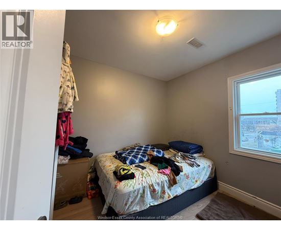 A bedroom with a bed, pillows, and a window.