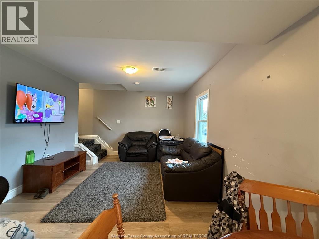 A living room with a couch, chair, and television.