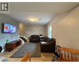 A living room with a couch, chair, and television.