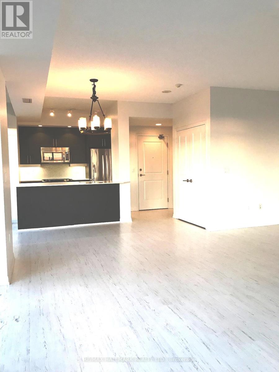 A spacious room with a chandelier and a bar area.