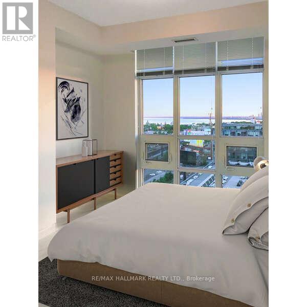 A bedroom with a large bed, a window with a view of the city, and a wooden cabinet.