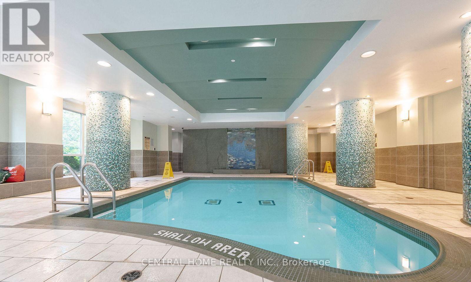 A swimming pool inside a building with a sign that says "SWIMMING POOL".