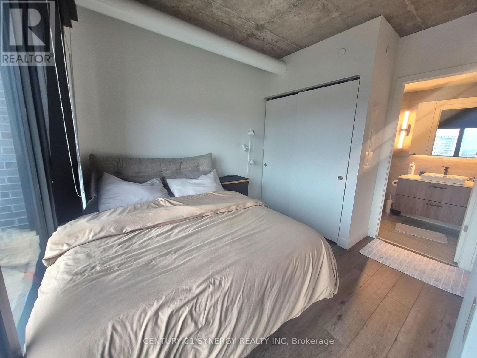 A bedroom with a bed, a nightstand, and a mirror.