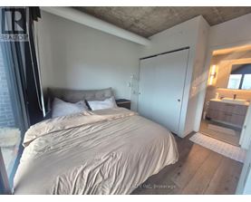 A bedroom with a bed, a nightstand, and a mirror.