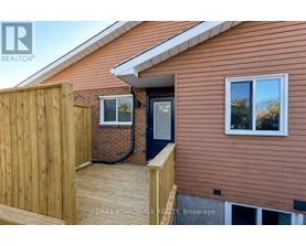 A house with a brown siding and a wooden fence.
