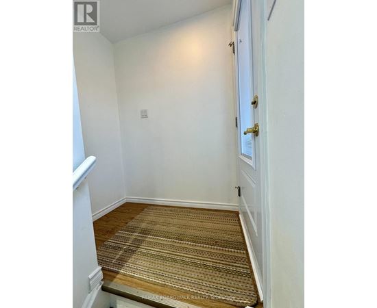A hallway with a carpeted floor and a white door.