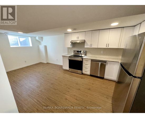 A kitchen with white cabinets and a wooden floor.