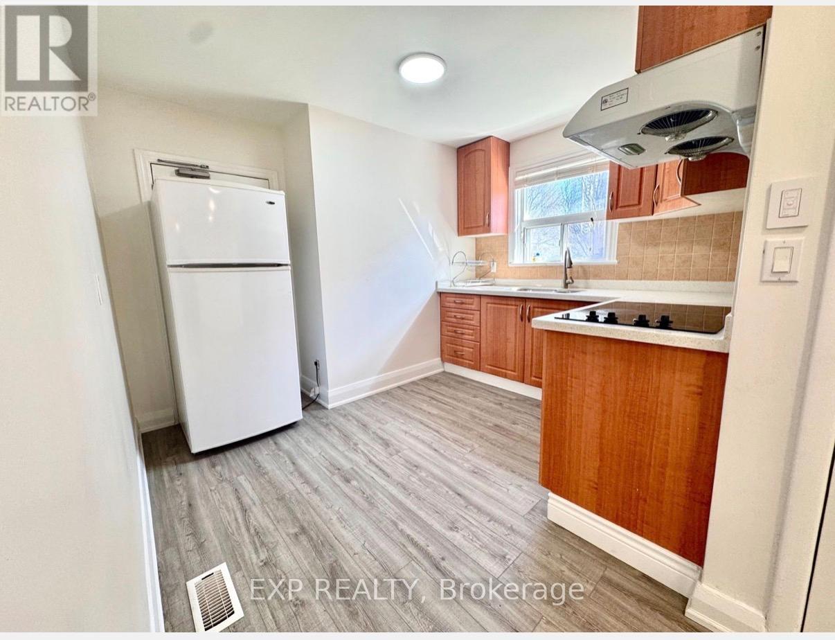 A kitchen with a white fridge and wooden cabinets.