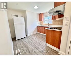 A kitchen with a white fridge and wooden cabinets.