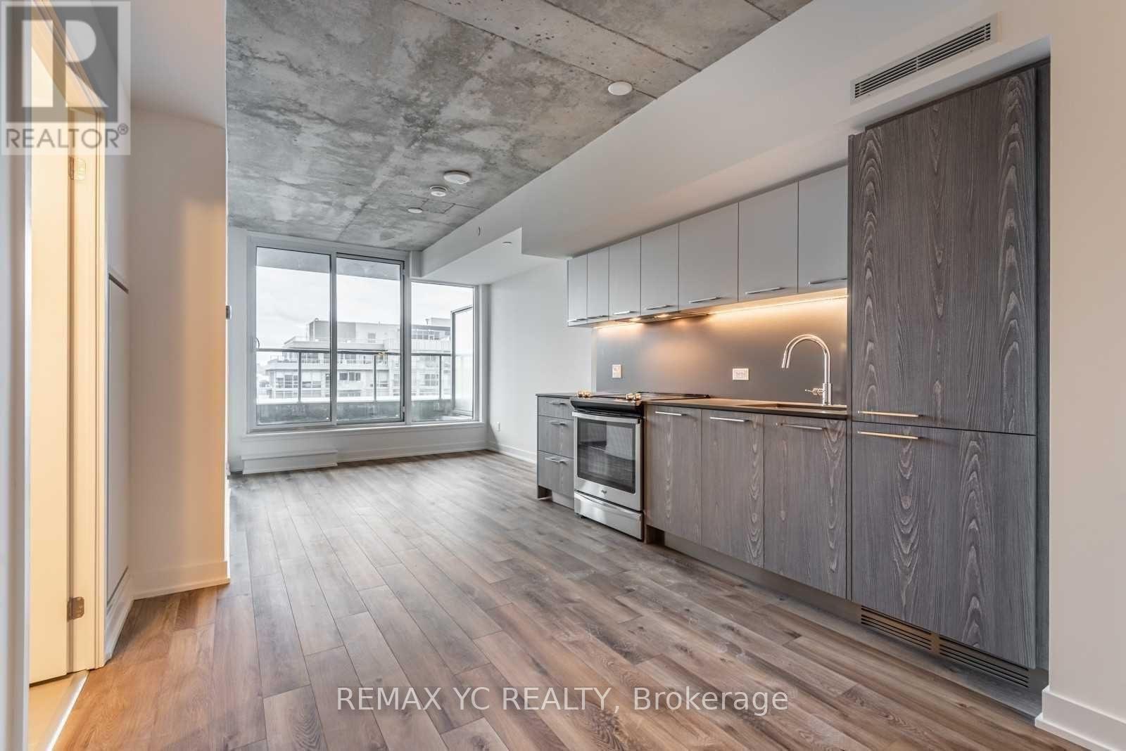 A modern kitchen with wooden floors and a large island.
