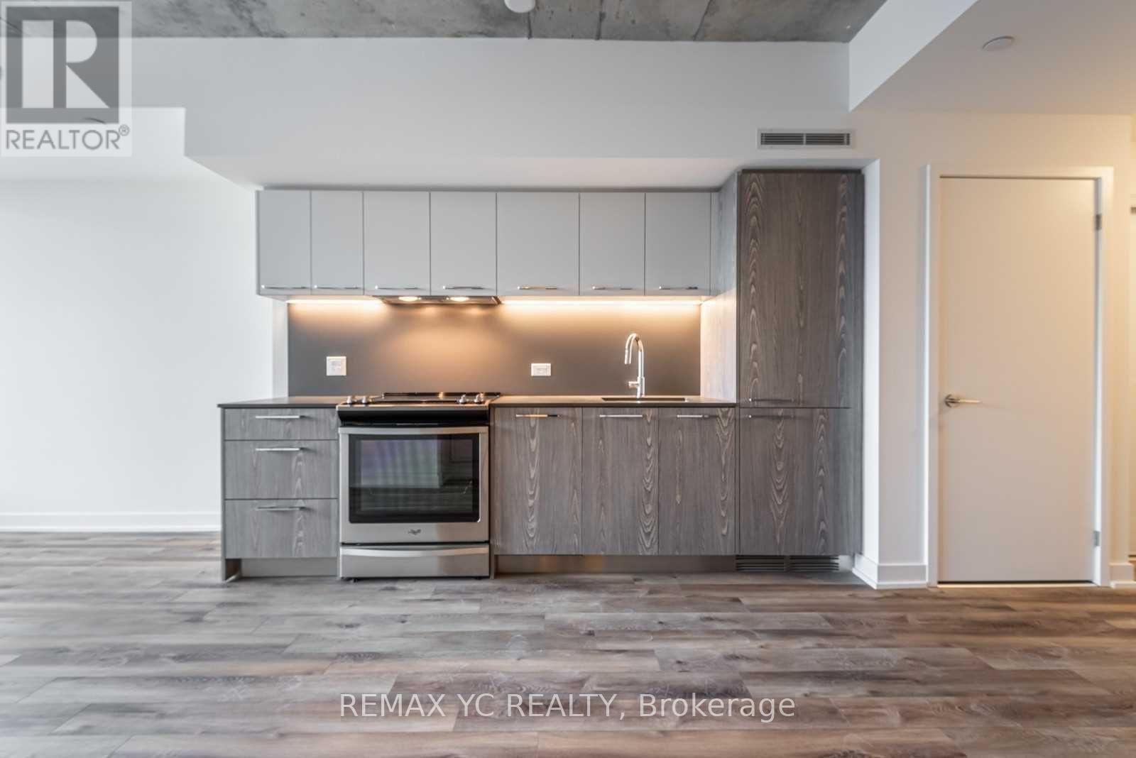 A modern kitchen with a stainless steel oven and wooden cabinets.