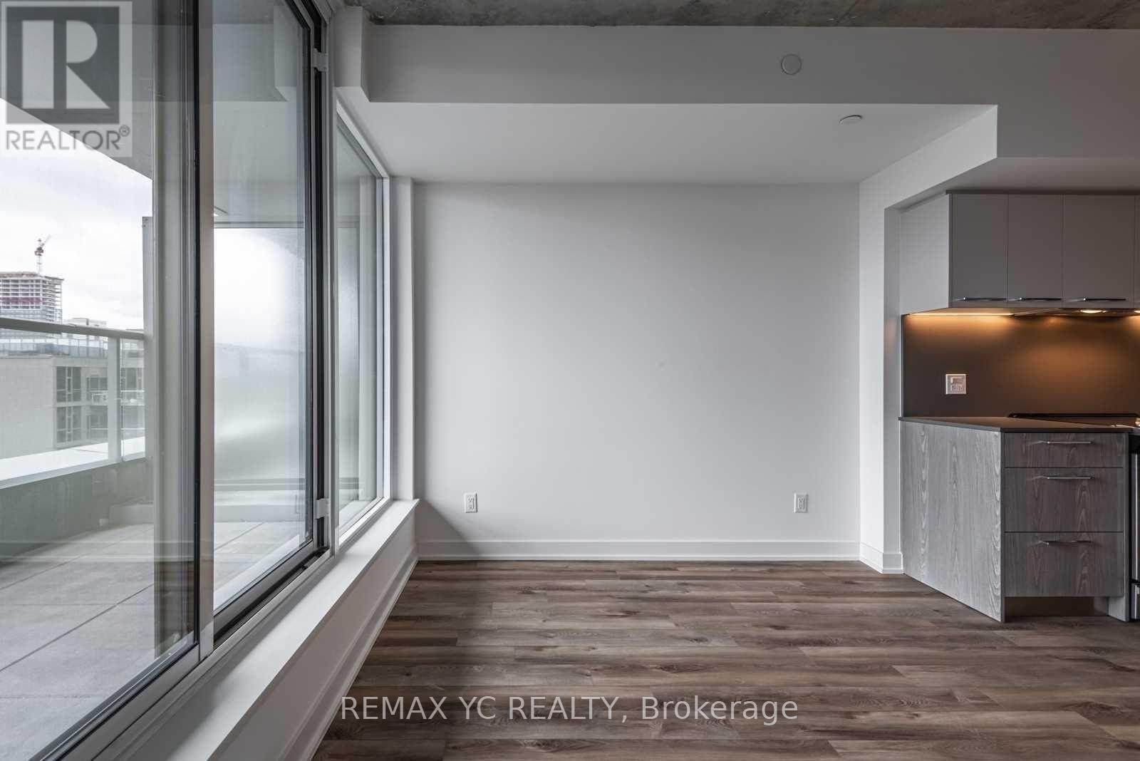 A large, empty room with a wooden floor and white walls.