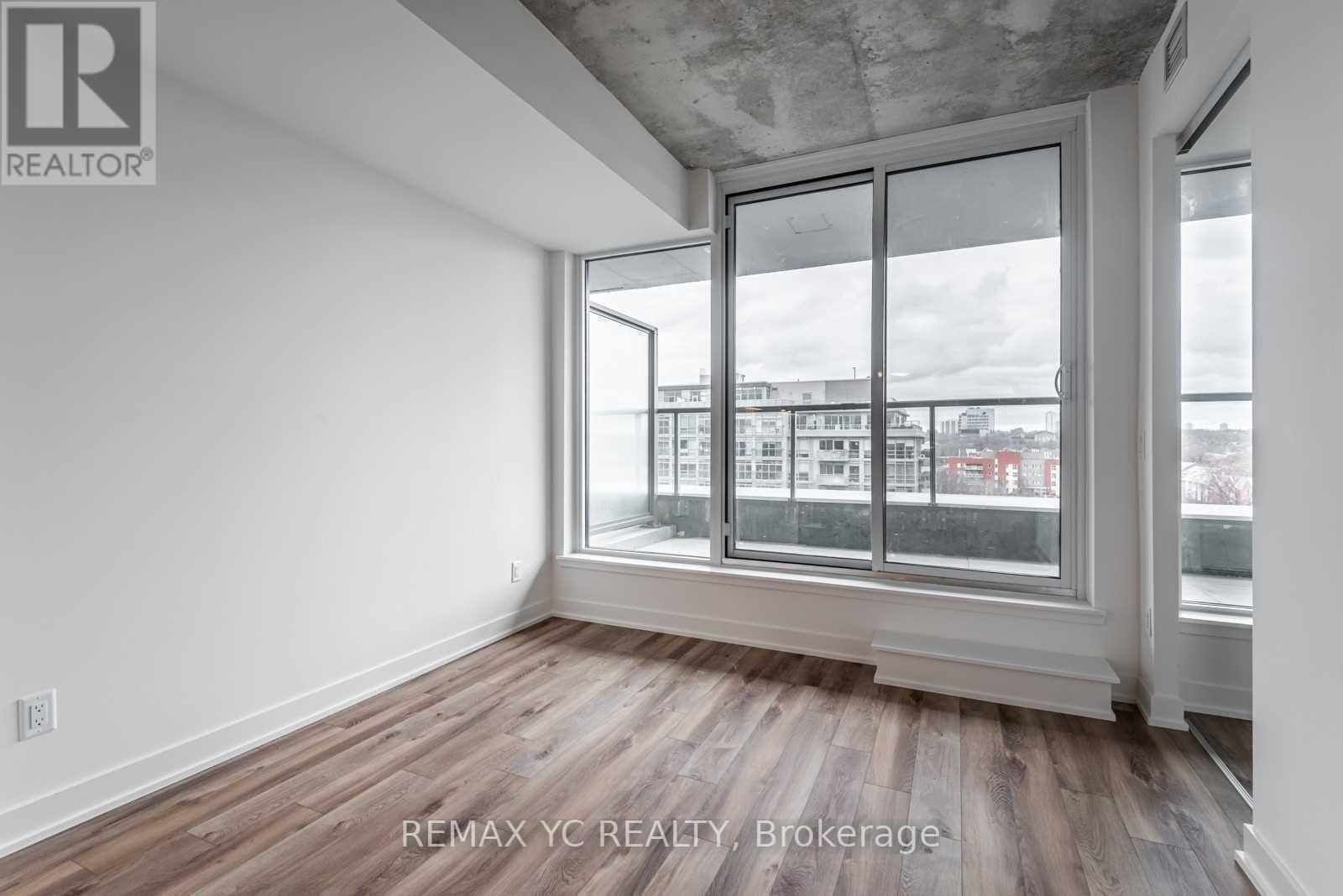 A room with a large window and wooden flooring.