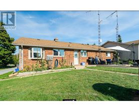 A house with a brown roof and a green lawn in front.