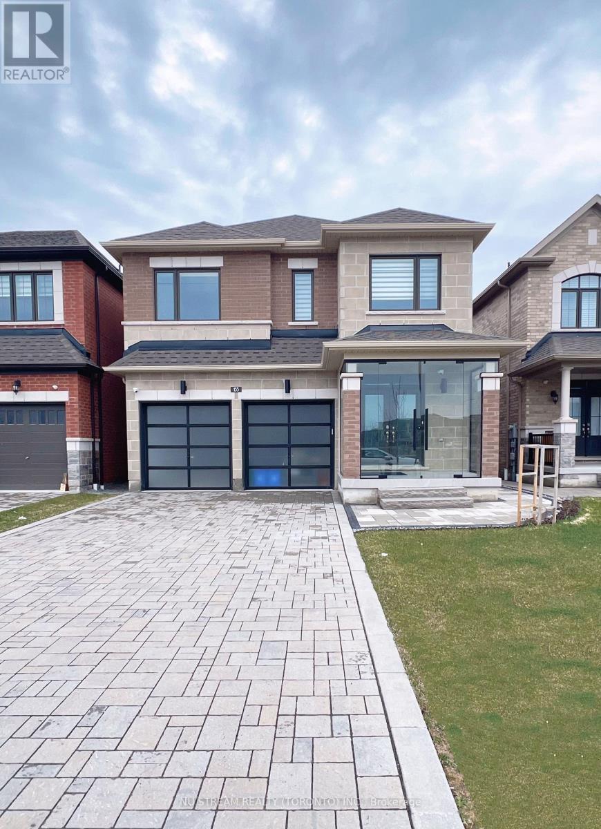 A large house with a brick facade and a driveway in front.