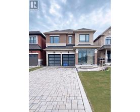 A large house with a brick facade and a driveway in front.