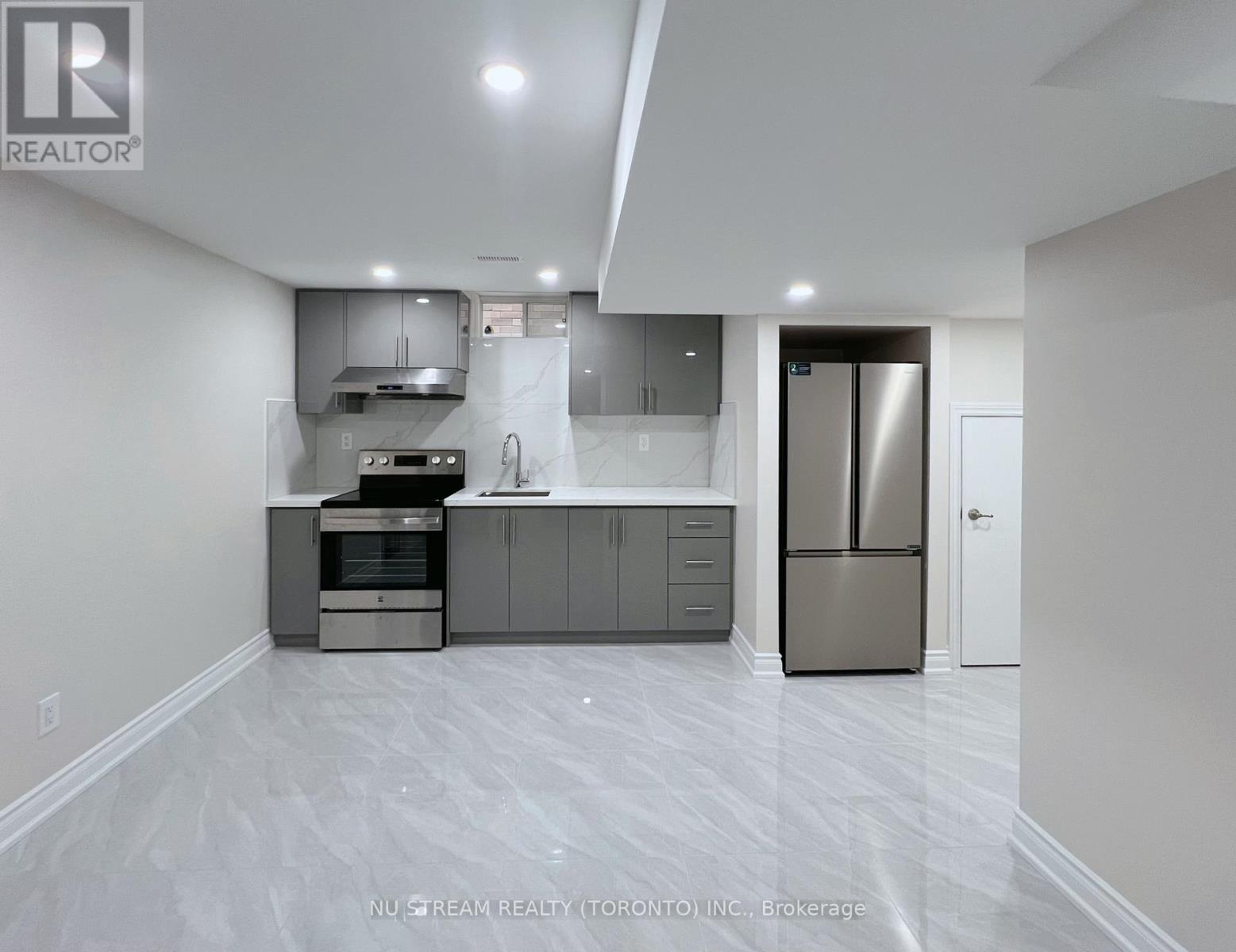 A modern kitchen with stainless steel appliances and white cabinetry.