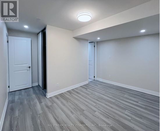 A room with a white door and a grey floor.