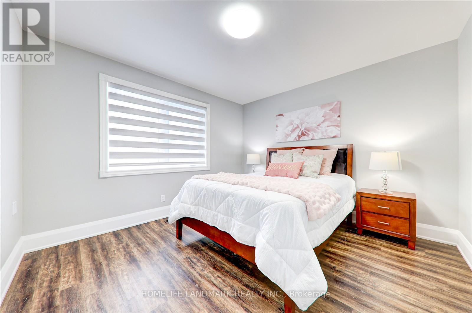 A bedroom with a bed, nightstand, and window.