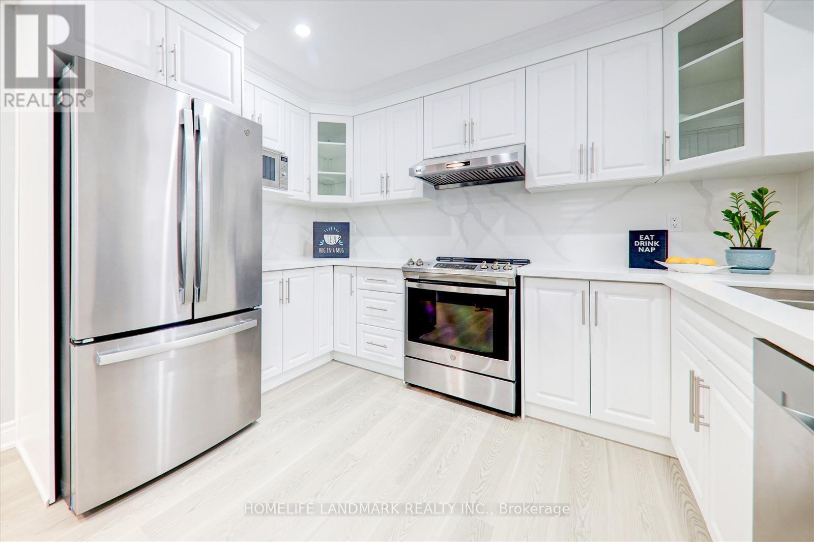 A modern kitchen with a stainless steel refrigerator and oven.