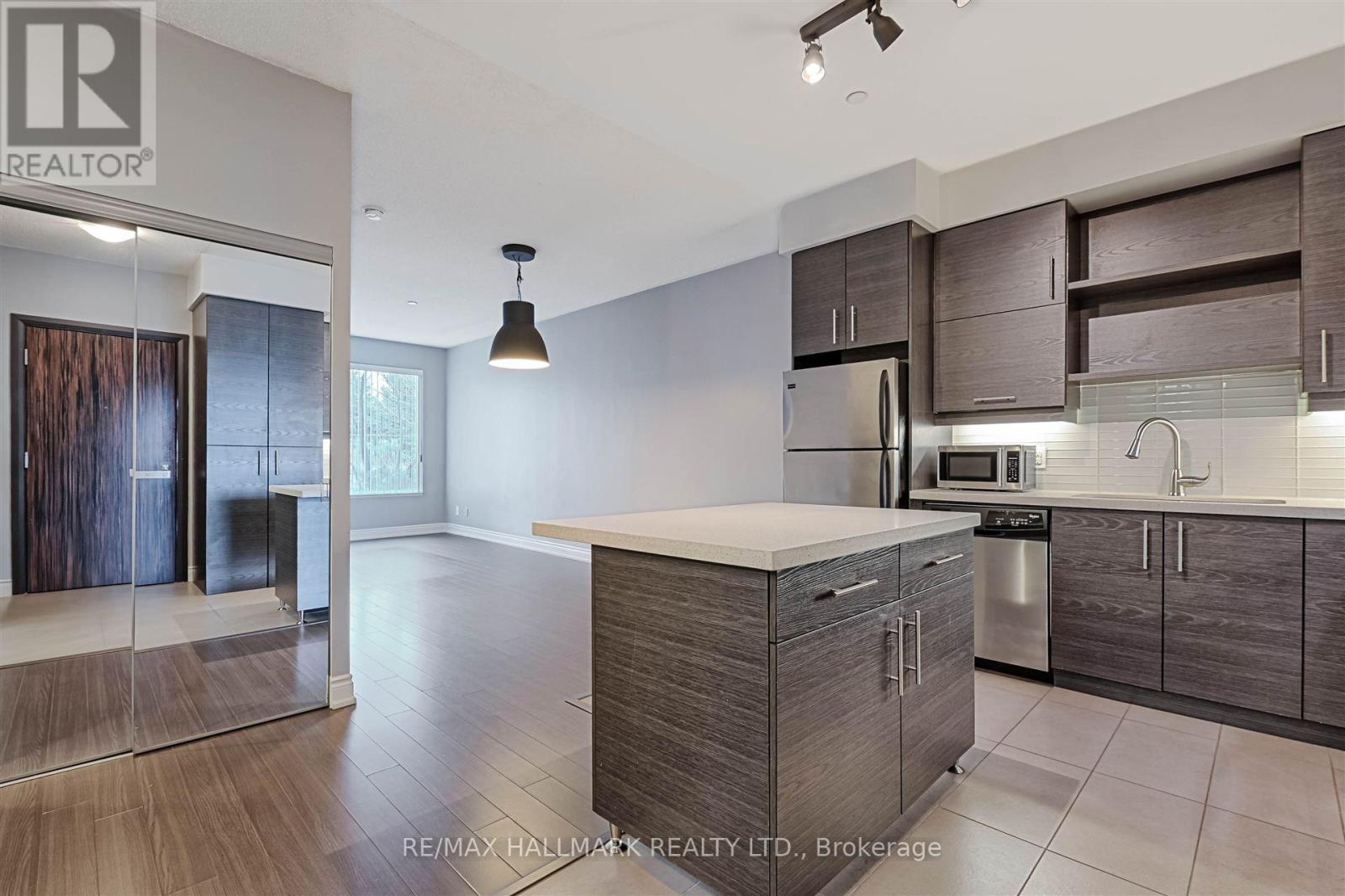 A modern kitchen with dark wood cabinets and a white countertop.