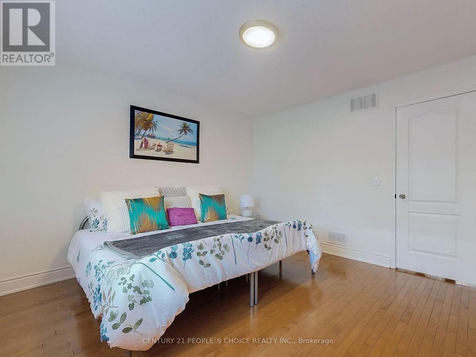 A bedroom with a bed and a picture on the wall.