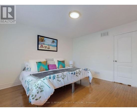 A bedroom with a bed and a picture on the wall.