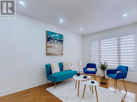 A living room with a blue sofa and a painting on the wall.