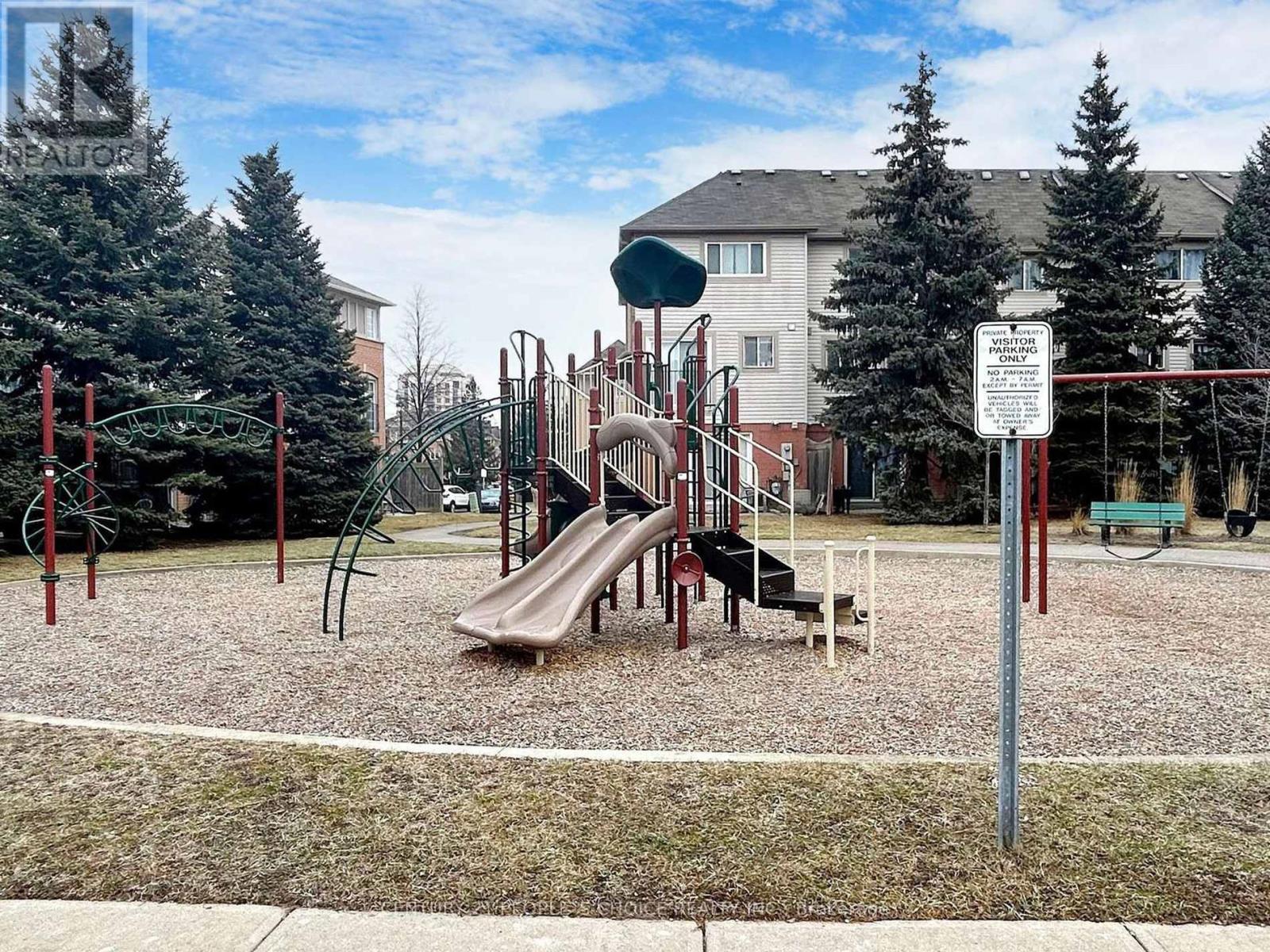 A playground with a slide and a sign in the background.