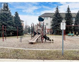 A playground with a slide and a sign in the background.