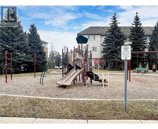 A playground with a slide and a sign in the background.