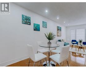 A dining room with a glass table and white chairs.