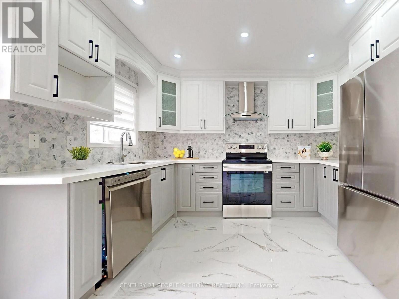 A modern kitchen with white cabinets and marble countertops.