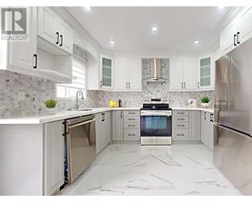 A modern kitchen with white cabinets and marble countertops.