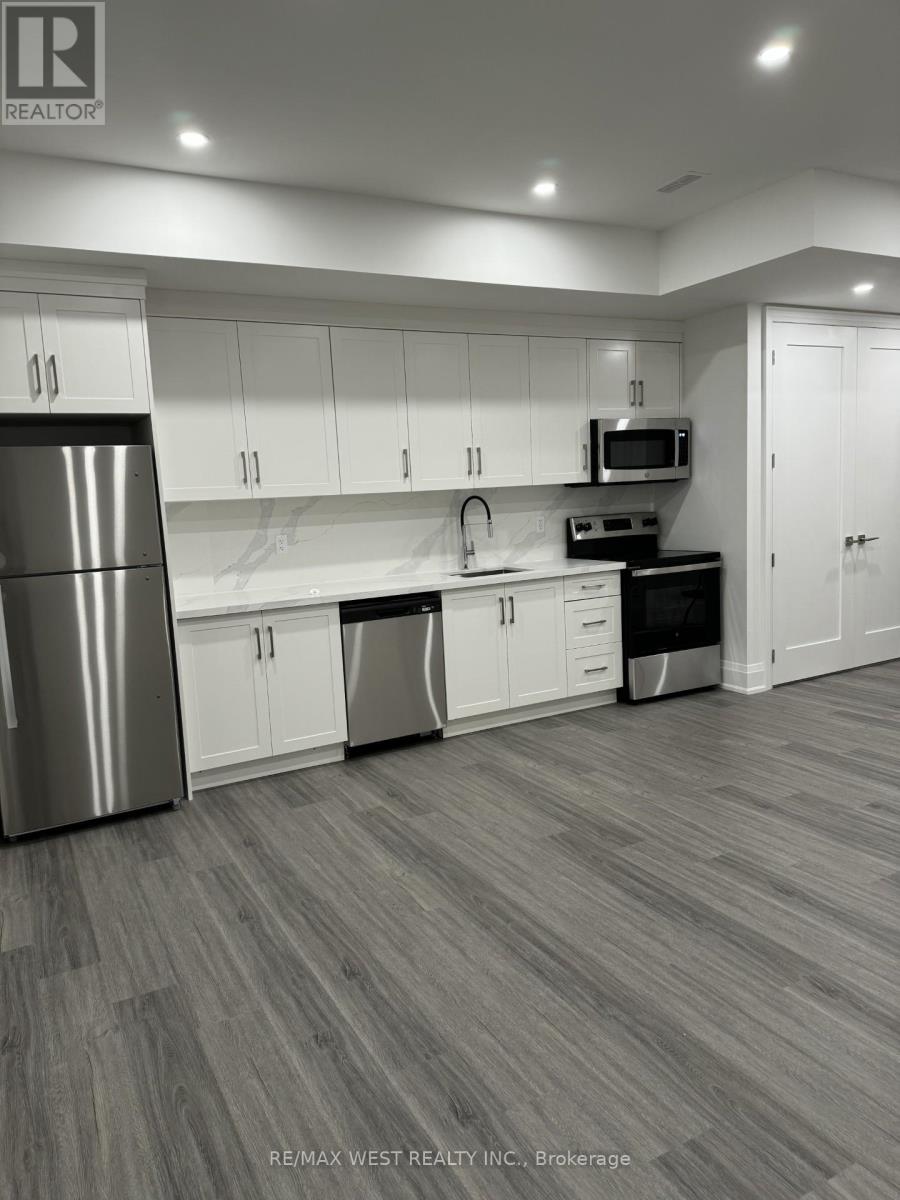 A modern kitchen with white cabinets and a stainless steel refrigerator.