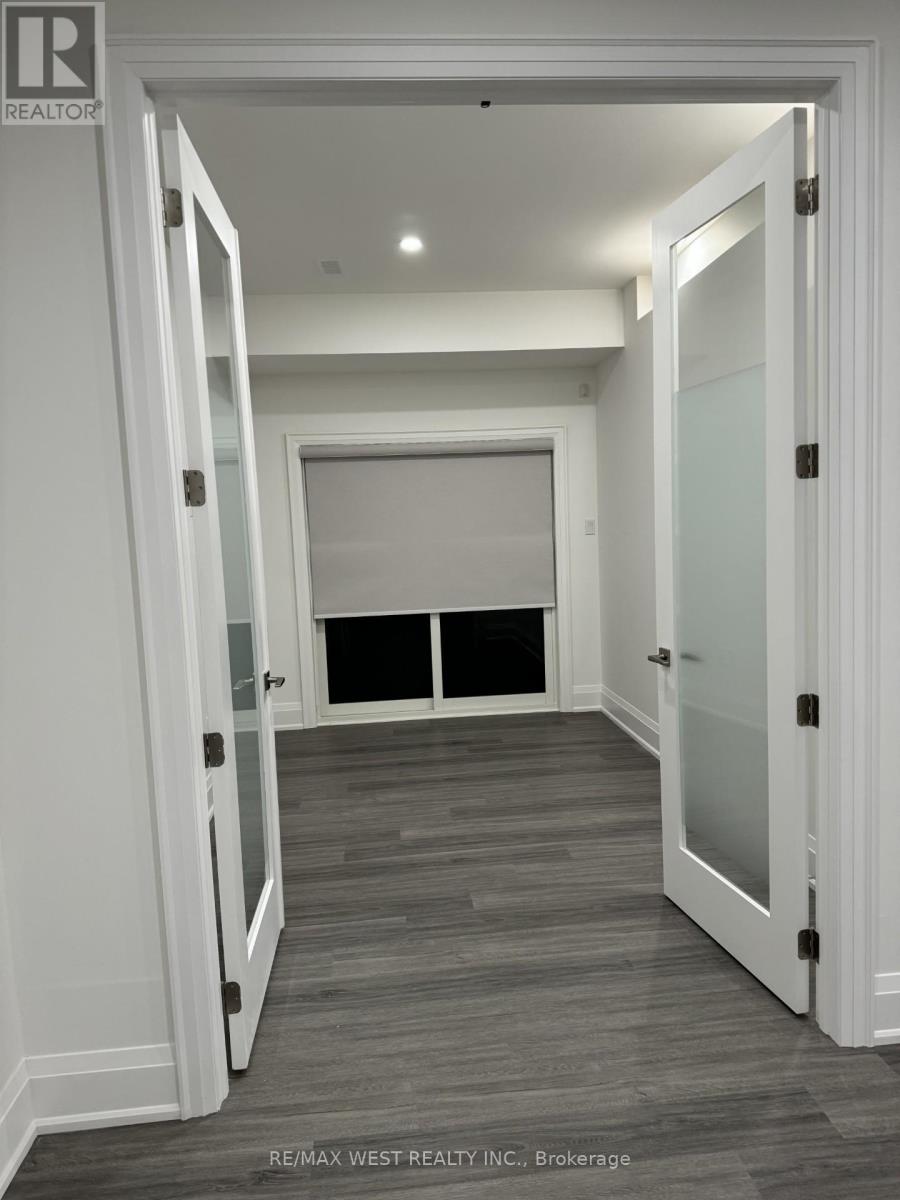 A hallway with white walls and a wooden floor.