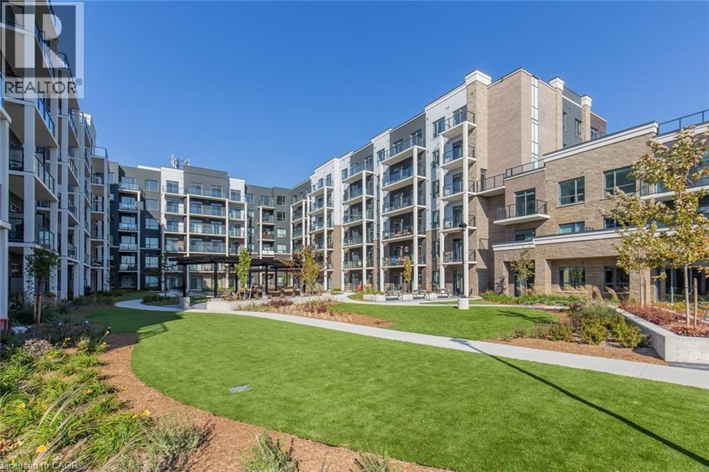 A modern apartment complex with a well-maintained lawn in the foreground.