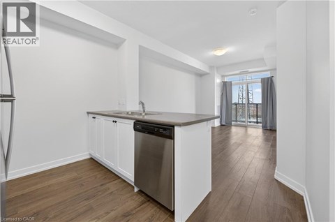 A kitchen with white cabinets and a wooden floor.
