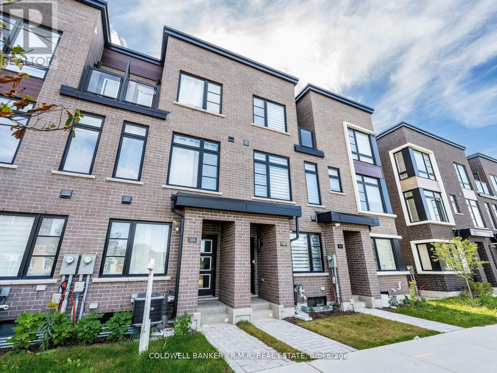 A modern brick apartment building with a clear sky in the background.