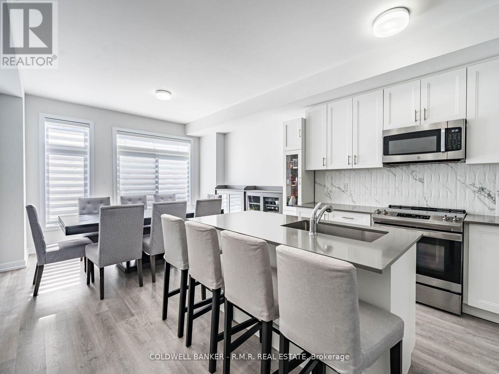 A kitchen with white cabinets and a breakfast bar.