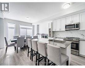 A kitchen with white cabinets and a breakfast bar.