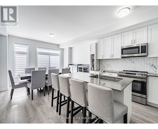A kitchen with white cabinets and a breakfast bar.