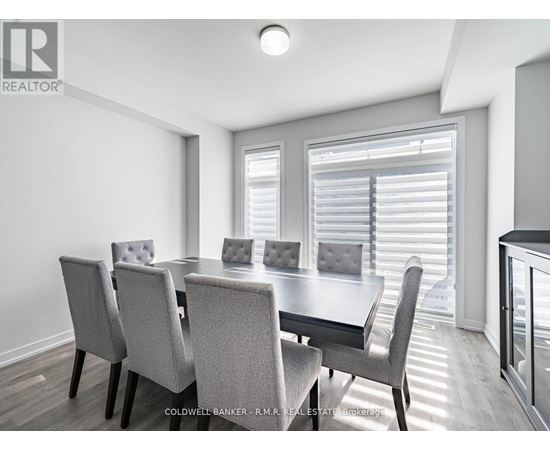 A dining room with a table and chairs.