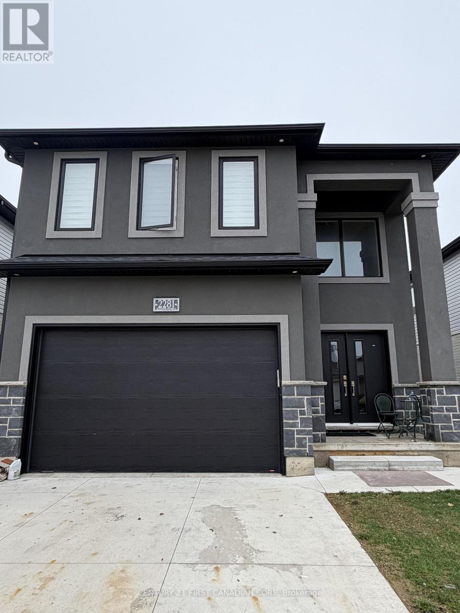 A modern house with a black garage door is for sale.