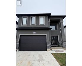 A modern house with a black garage door is for sale.