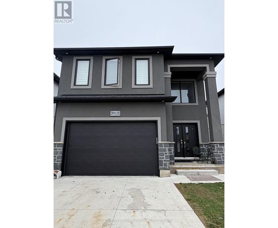 A modern house with a black garage door is for sale.
