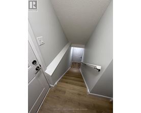 A hallway with a wooden floor and white walls.