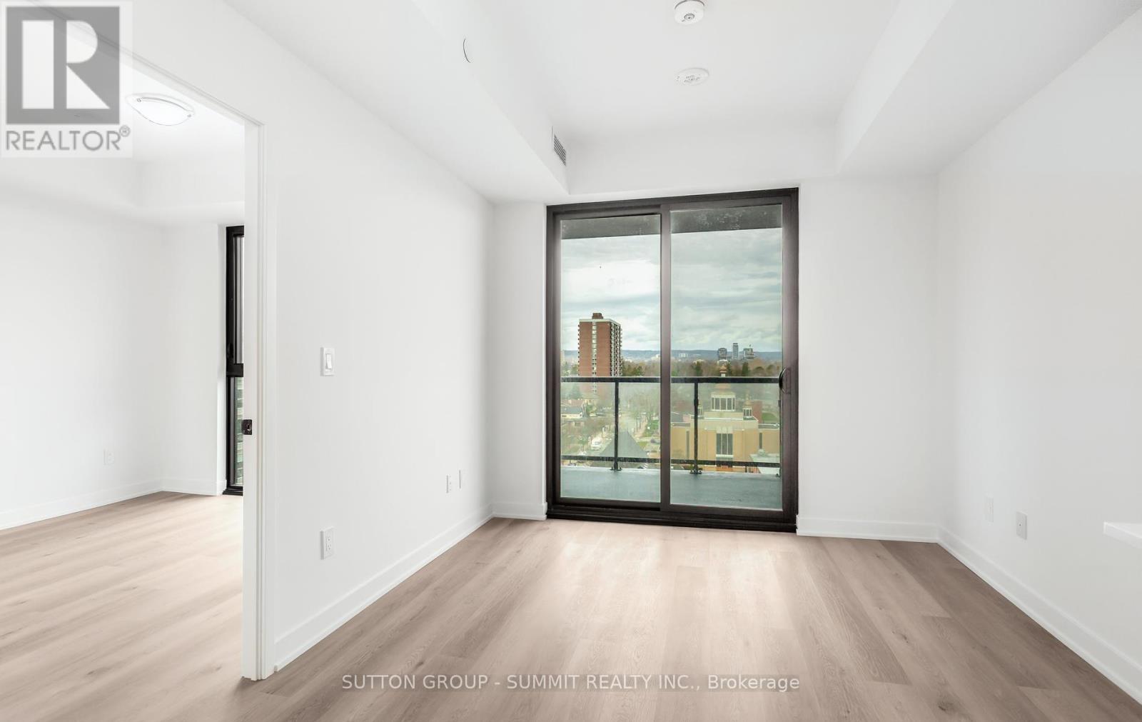 A spacious room with a view of the city through large windows.